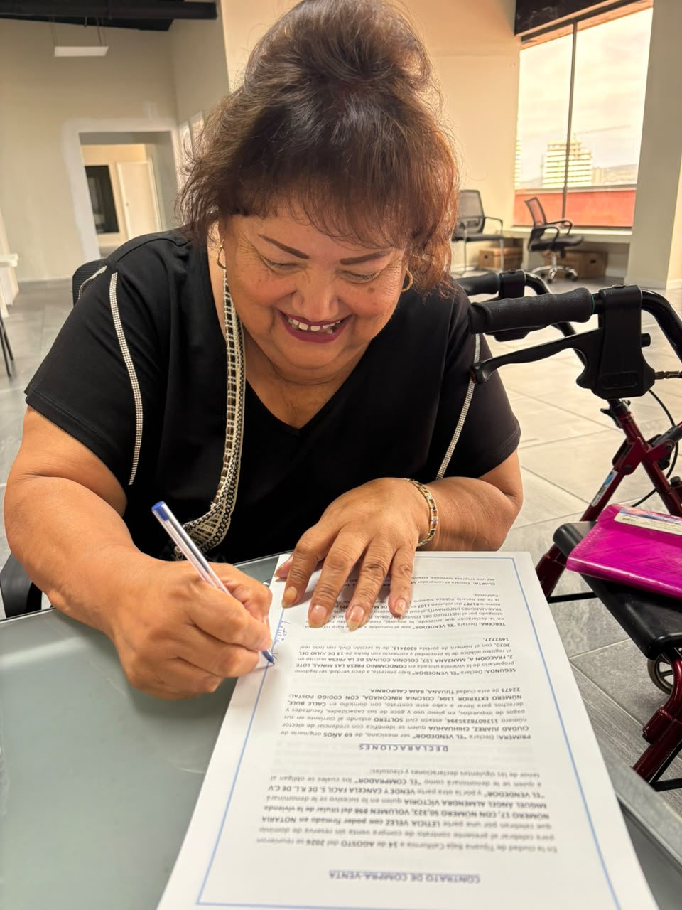 Cliente firmando contrato de compraventa con alegría