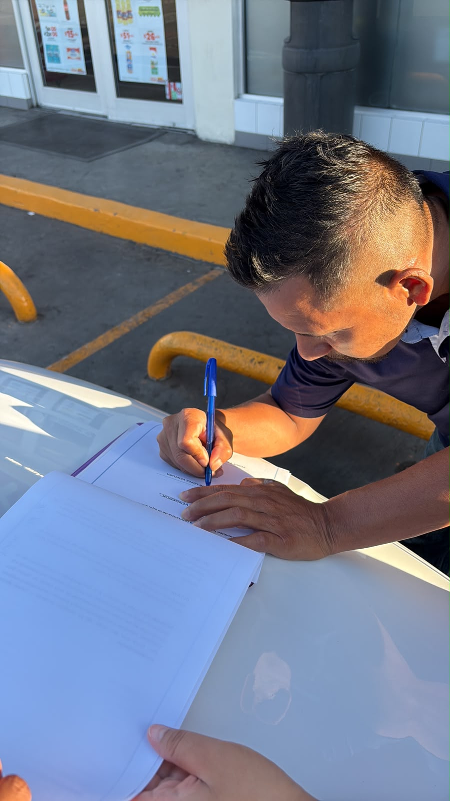 Cliente firmando documentos de venta en el lugar