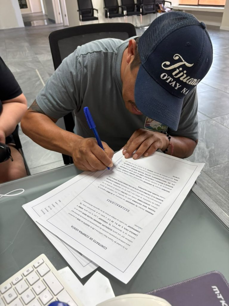Cliente firmando contrato de compraventa con Cancela Fácil